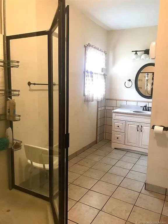 Bathroom looking in — glass-door shower stall at the left.