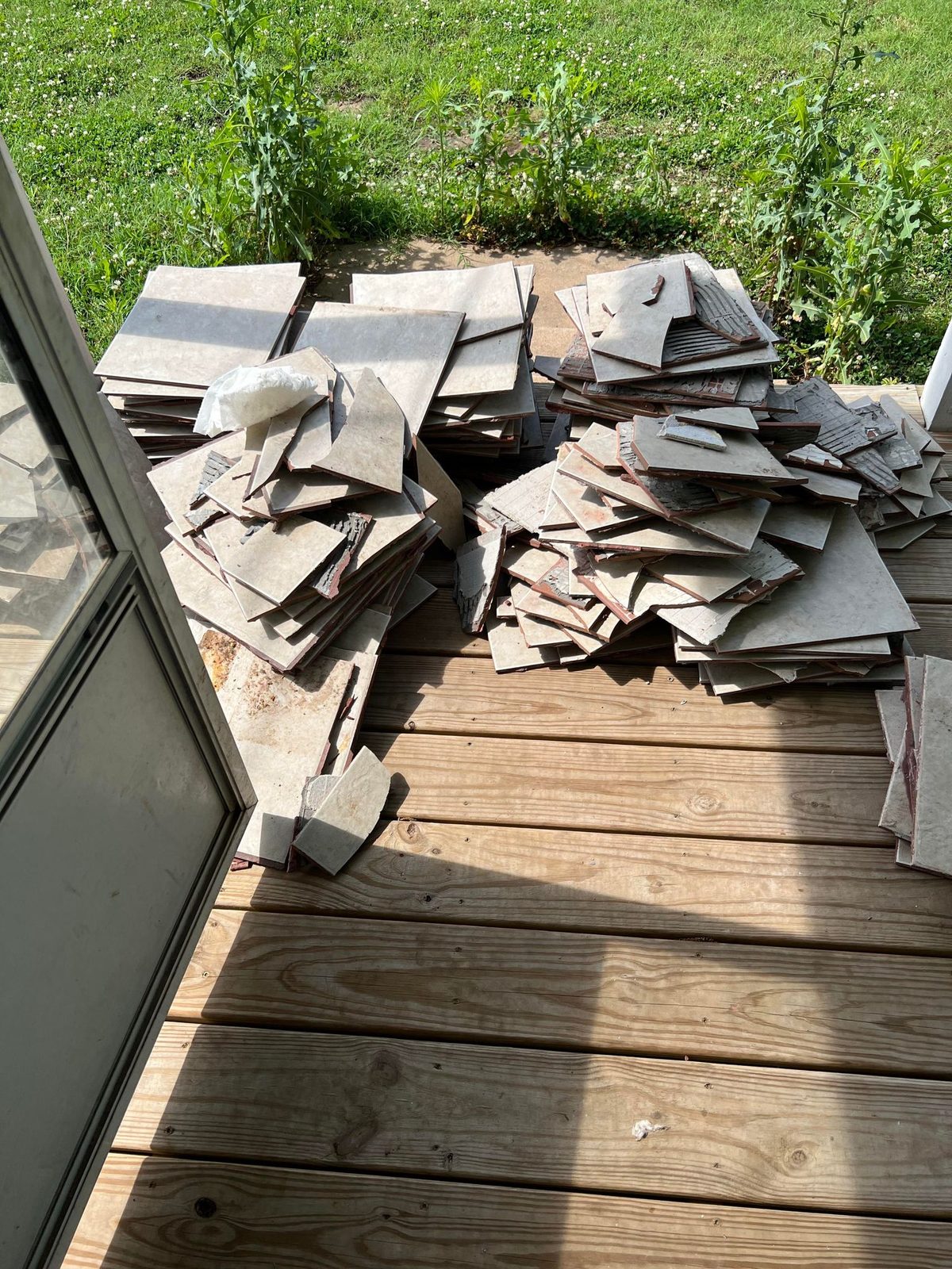 The rear wood deck, 2 June 2022, with the lifted tile stacked on it. Best look on record at the deck boards.