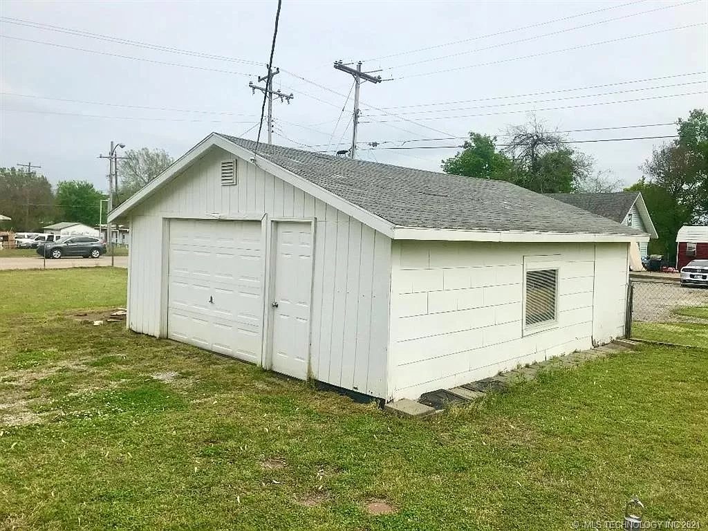 The detached garage — one overhead door, gable roof, gable vent. 2021.