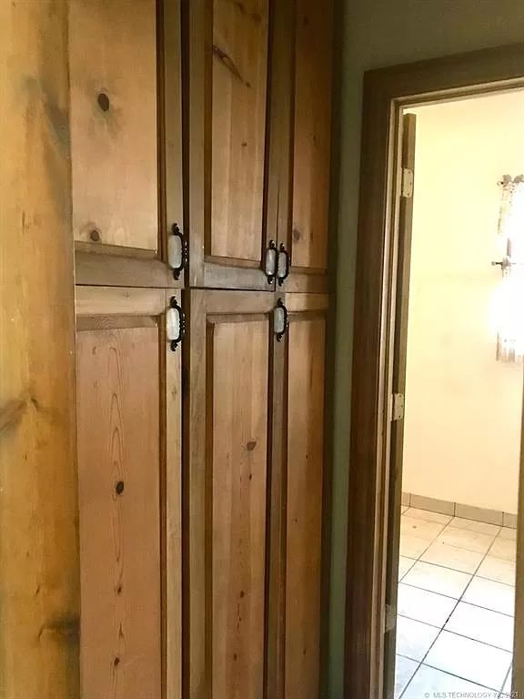 The built-in pantry off the kitchen hallway — full height, wood doors.
