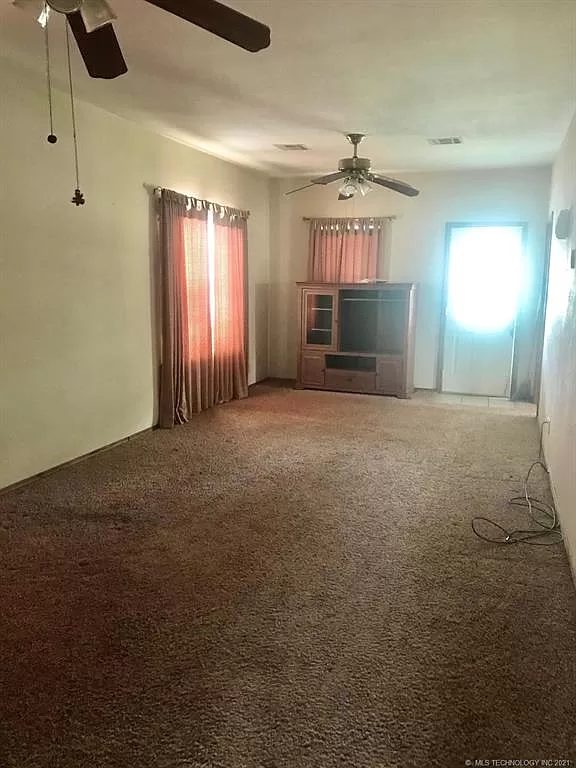 Living room, spring 2021 — carpet, ceiling fan, front window.